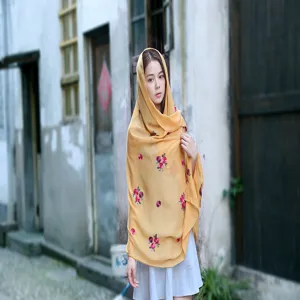 Detailed view of yellow ethnic style cotton linen scarf featuring pink plum blossom embroidery