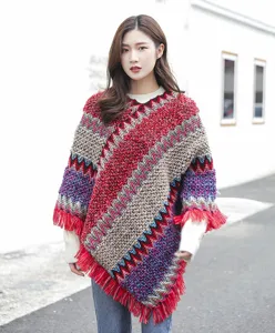 Detailed macro view of ethnic knit poncho with vibrant wave pattern and red fringe.