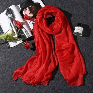 Elegant red cotton linen scarf displayed with lifestyle props on dark grey background