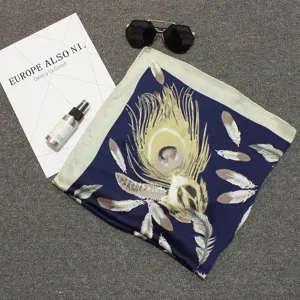 Elegant navy blue square silk scarf featuring a large golden peacock feather print detail