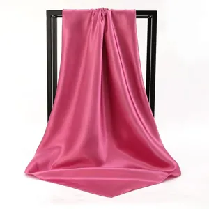 Elegant rose pink satin square scarf draped gracefully on a minimalist black stand