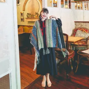Close-up detail of bohemian ethnic style colorful knitted poncho with decorative fringe