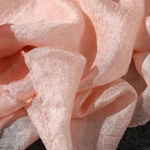 Macro detail of pink pearl luster cotton linen scarf showing soft fabric texture detail.
