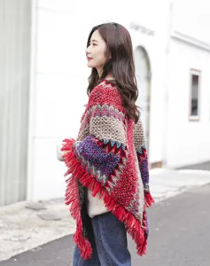 Side view of an ethnic knitted poncho with vibrant red fringe and geometric patterns.