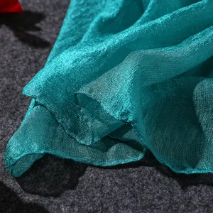 Detailed macro view of turquoise pearl cotton linen scarf showing fabric texture and sheen