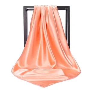 Detailed view of peach satin square scarf showing smooth texture and elegant sheen
