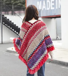 Rear view of ethnic style knitted poncho with colorful wave patterns and fringe detail