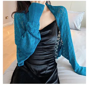 Close-up detail of a teal hollow-out knitted shrug shawl with honeycomb pattern design