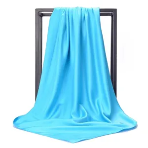 Detailed view of the smooth silk texture and drape of the 90cm light blue square scarf