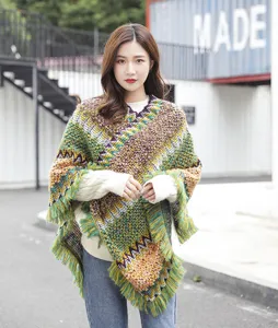 Detailed view of ethnic style knitted poncho with colorful zigzag patterns and fringe