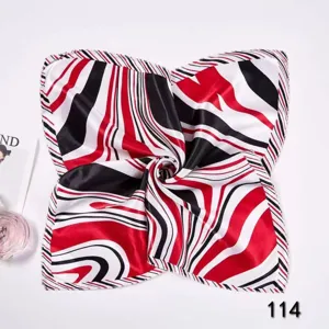 Close-up of square silk scarf with red, black, and white zebra abstract pattern details