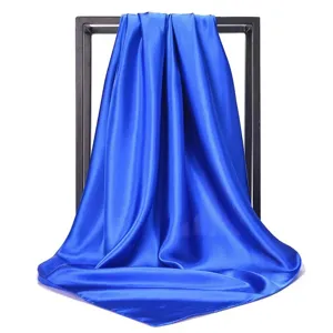 Macro view of a vibrant royal blue satin square scarf showing its smooth silky texture