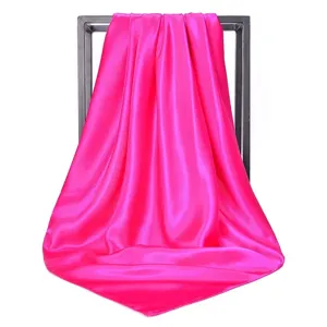 Close-up detail of a luxurious hot pink satin square scarf with elegant draping