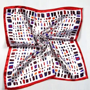 Detailed view of square silk scarf with red border and multi-color geometric print