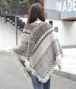 Back view detail of women's ethnic style knitted poncho with grey fringe and tassels