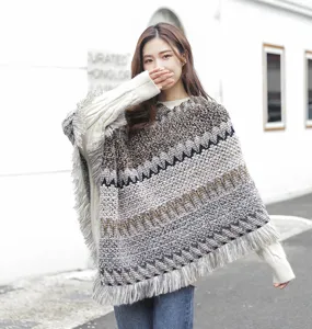 Detailed view of women's knitted ethnic poncho with tassel fringe and geometric patterns