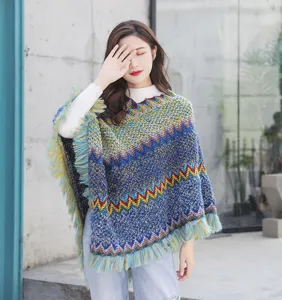 Detailed view of an ethnic style knitted poncho with colorful zigzag patterns and fringed tassels