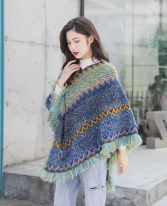 Detailed view of the ethnic style knitted poncho with colorful zigzag patterns and tassels