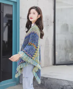 Side view of an ethnic knit poncho with fringe, showcasing colorful chevron patterns.
