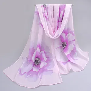 Detail shot of long pink chiffon scarf with purple floral print for summer protection.