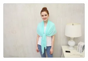 Close-up of mint green pleated chiffon sunscreen shawl worn by a model in a cozy room