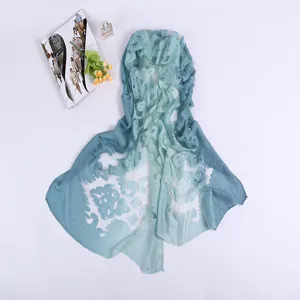 Detail view of the blue gradient long scarf featuring an elegant floral burnout pattern