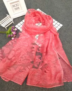 Detailed view of coral pink shear floral patterned scarf with elegant burnout texture