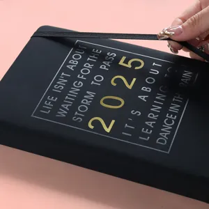 Primer plano de la agenda 2025 con frase inspiradora y banda elástica