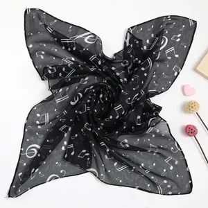 Detailansicht eines eleganten schwarzen Chiffonschals mit weißem Notenmuster-Druck