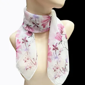 Detailansicht eines eleganten weißen Seidenschals mit rosa Blumenmuster auf einer Schaufensterpuppe