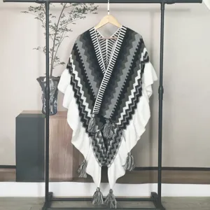 Ethno-Strickponcho mit grauen Zickzackmustern und eleganten Quasten für den Winter.