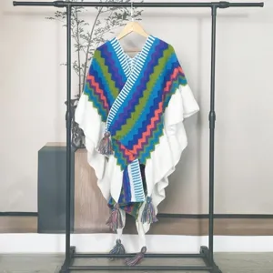 Nahaufnahme eines bunten Mohair-Strickponchos mit Ethno-Zickzackmuster und Quasten