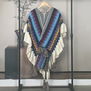 Detailansicht eines ethnischen Strickponchos mit bunten Zickzackmustern und Quasten.