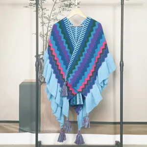 Strick-Poncho mit Zickzack-Muster, Rüschen und Quasten für Damen, elegantes Ethno-Design.