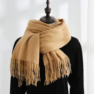 Detailed view of a thick, warm camel-colored winter scarf with fringes on a mannequin