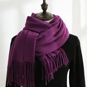 Detailed view of a thick purple winter scarf with elegant tassels on a mannequin
