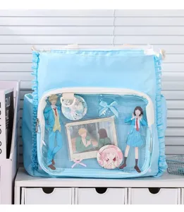 Close-up of light blue ruffle messenger bag with clear window showing anime merchandise