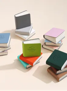 Primo piano di mini taccuini colorati in pelle PU con testo d'ispirazione artistica