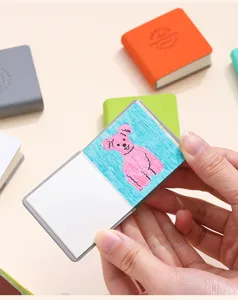 Primo piano di un mini taccuino tascabile portatile con un disegno di orso su carta bianca