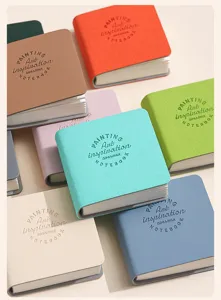 Dettaglio di mini taccuini colorati in pelle PU con scritte Art Inspiration a rilievo