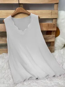 Detail view of a white sleeveless top featuring a delicate scalloped V-neckline.