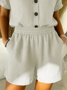 Detail of comfortable off-white cotton linen shorts with elastic waist and pockets