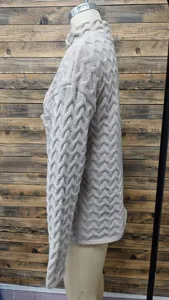 Side view of a beige cable-knit sweater showing chunky knit pattern and stand collar detail.