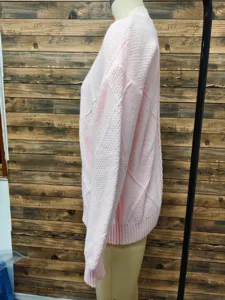 Close-up side view of pink long sleeve sweater showing detailed jacquard knit pattern texture