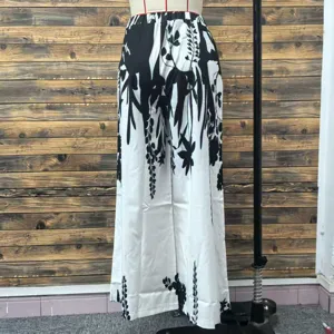 Detailed view of women's wide-leg casual pants featuring a black botanical print on white