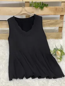 Detail view of a black sleeveless top with a scalloped V-neckline and smooth fabric texture.