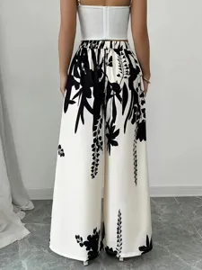 Back view of high-waisted wide-leg pants with black floral print on white fabric.