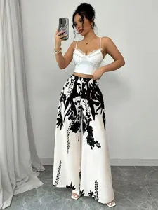 Full-body view of woman wearing stylish white wide-leg pants with black floral print