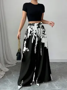 Detail view of high-waisted wide-leg trousers with elegant black and white floral print