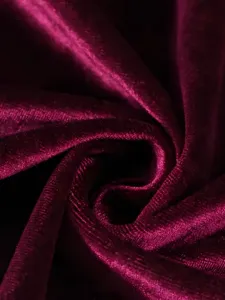 Macro view of luxurious wine red velvet fabric texture showing soft sheen and drape